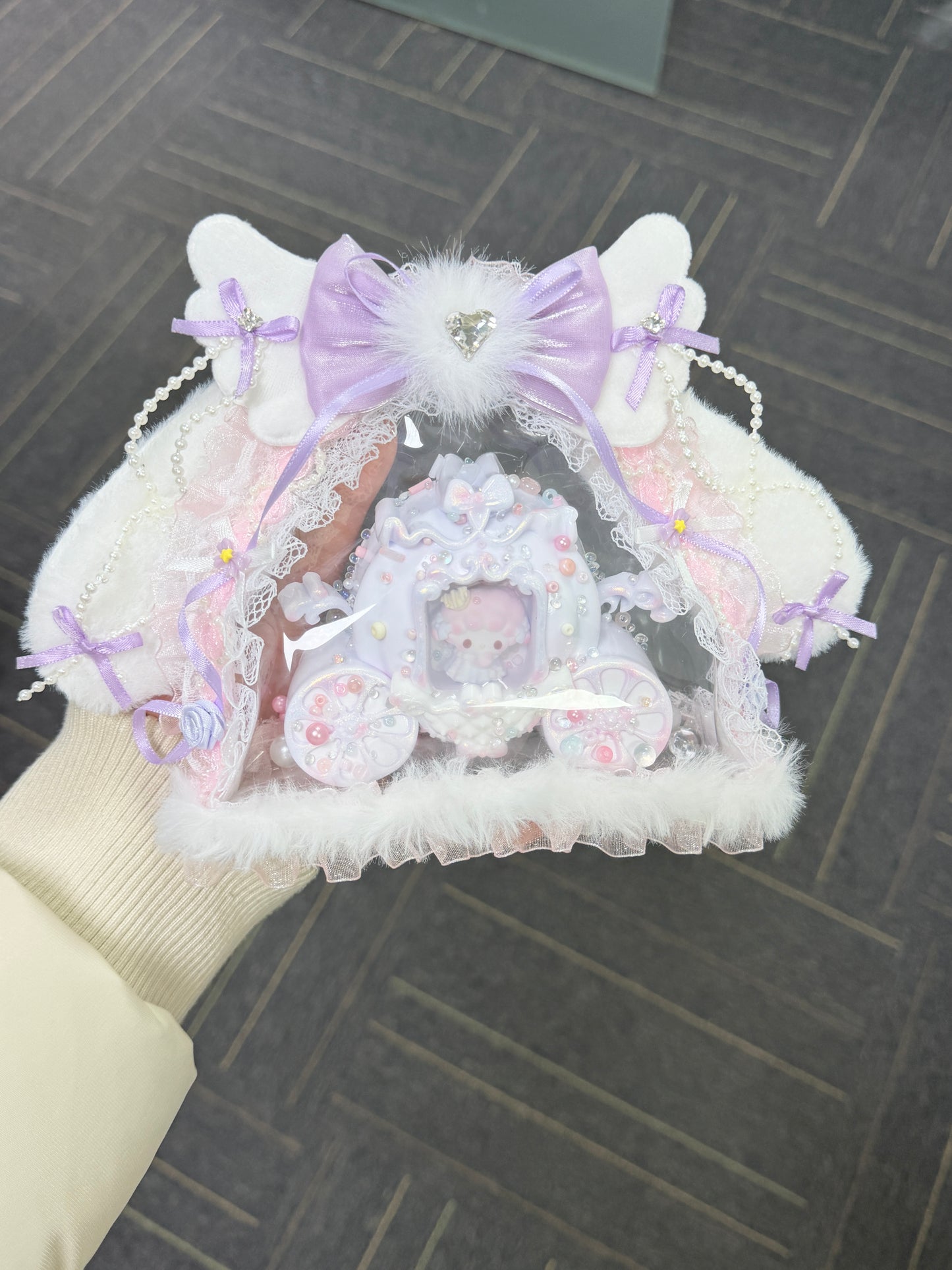 Handmade kawaii heart squishy with lavender princess carriage decoden, white fluffy fur trim, pearl chains and lace ribbons — top view