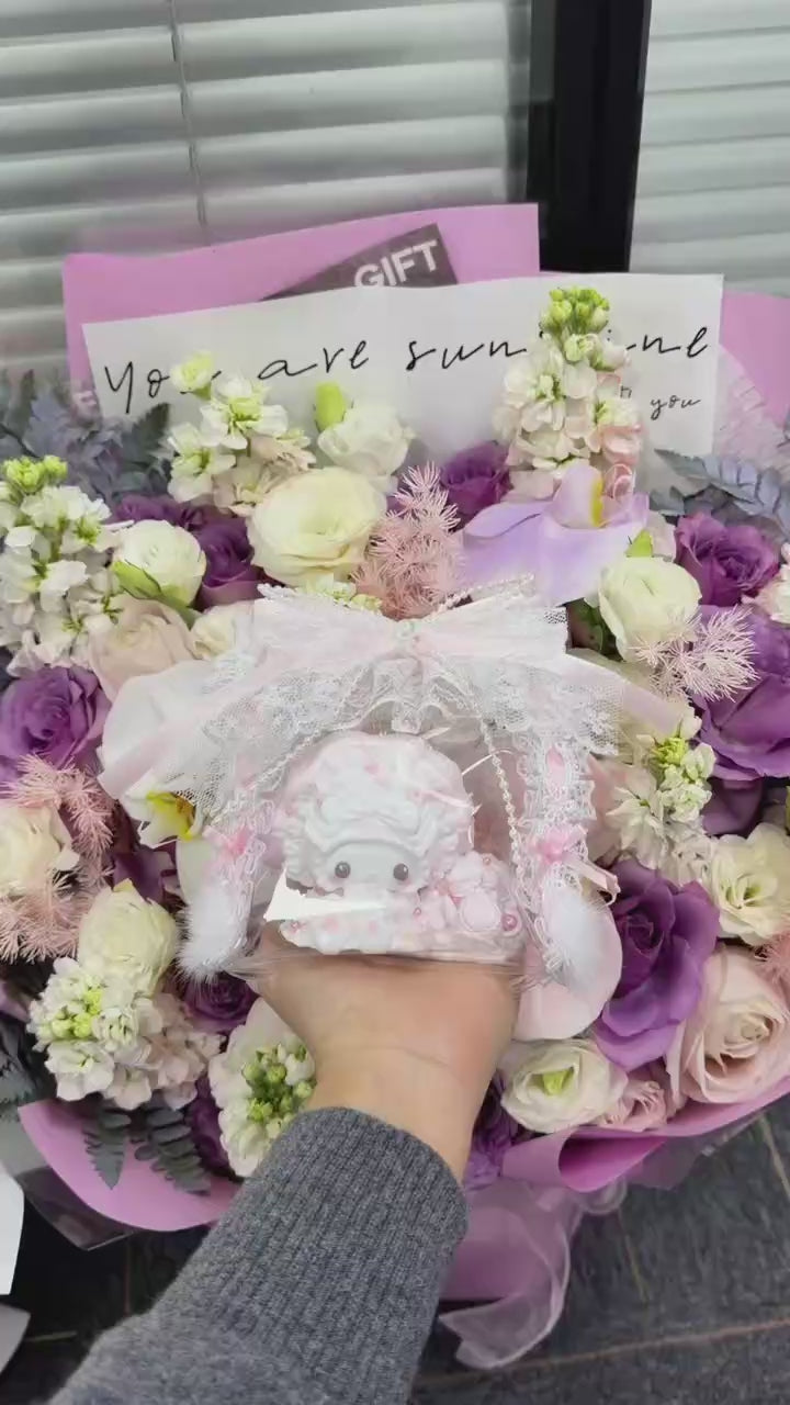 Hand holding a soft food-grade silicone cream bunny squishy toy showing its palm-sized scale and detailed cream swirl surface